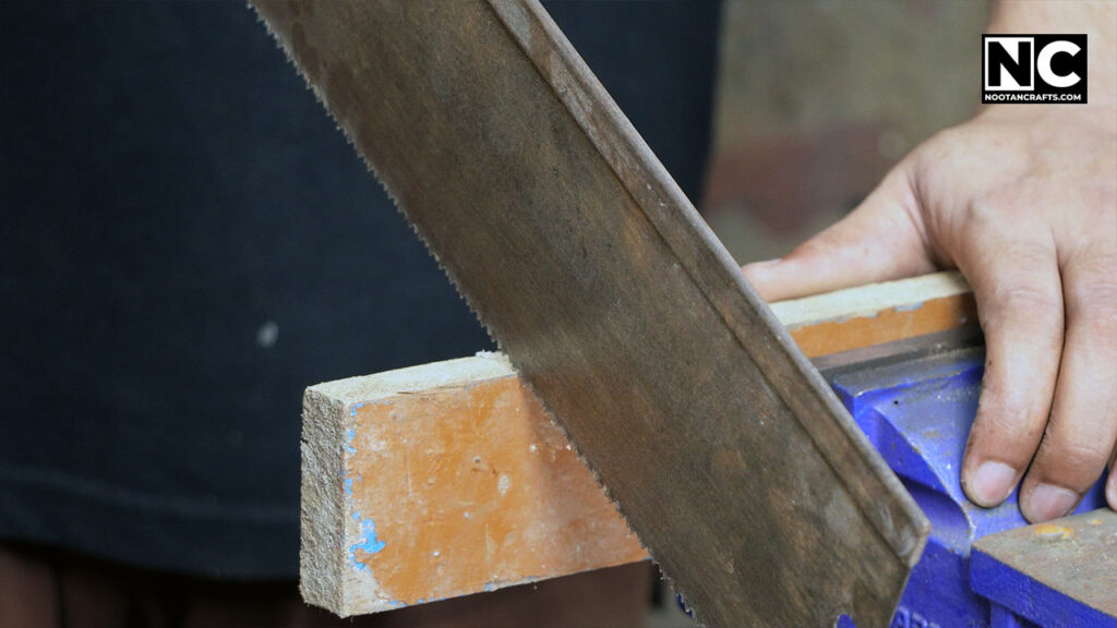 sawing a wood with a hand saw
