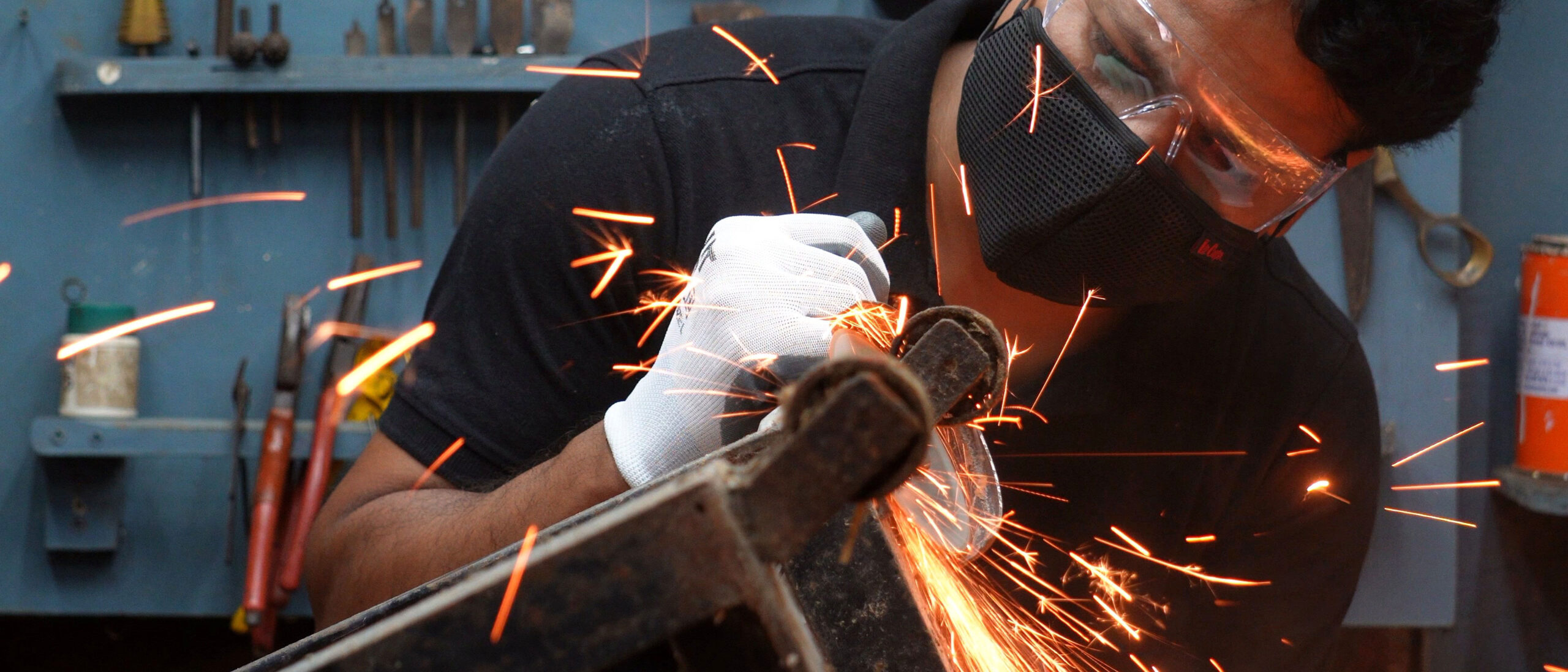 Nootan cutting metal with an angle grinder, sparks flying